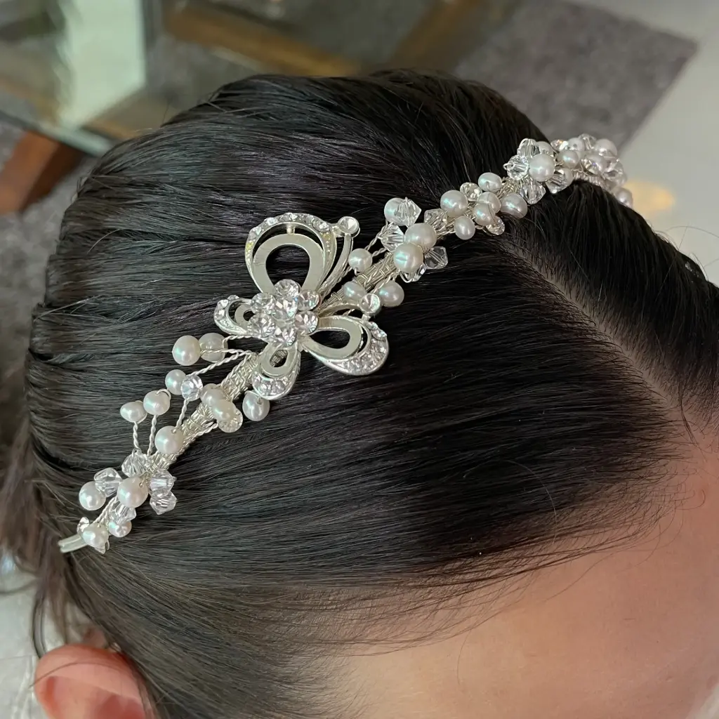 Diadema plateada con perlas y mariposa en lateral