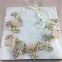 Bandita dorada con flores en rosa palo y detalles perlados