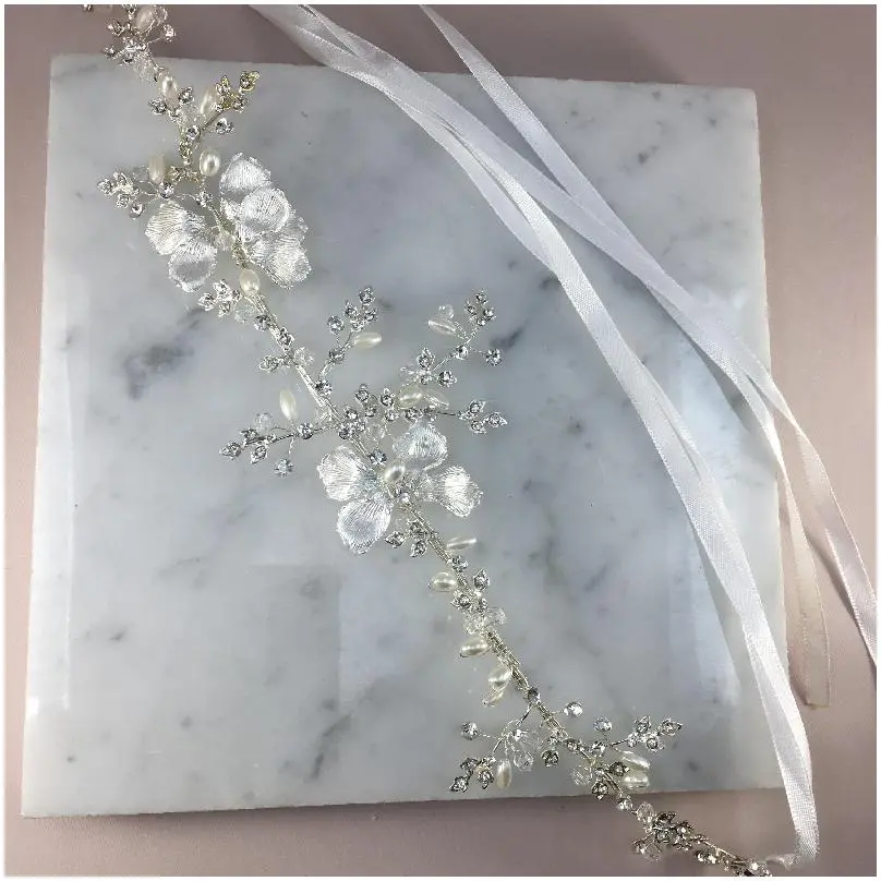 Diadema elegante con flores perladas a los lados 